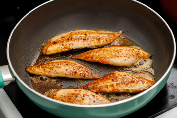 Small fish fillet fried in a frying pan. Cooking fish without oil.