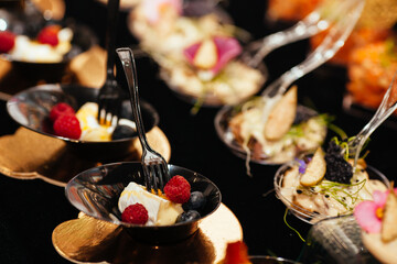 A pleasant evening with a delicious appetizer, a buffet table with appetizers and a set of canap s with ham, bruschetta, pear, cheese, raspberries and other sweets.