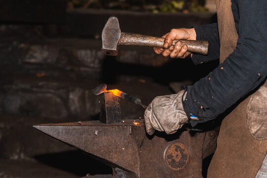 Crop blacksmith shaping a rare European mallet