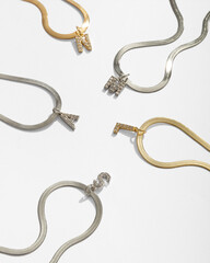 Jewelry made of gold and silver on a white background. Stylish compositions with hard shadows and natural stones. 