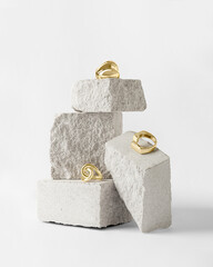 Jewelry made of gold and silver on a white background. Stylish compositions with hard shadows and natural stones. 