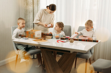A mother and her children are preparing for Christmas, packing gifts.