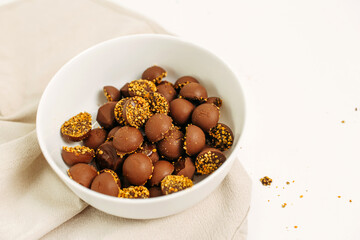 Chocolate keto candies in a white plate on the table.