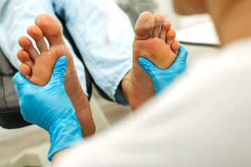 An orthopedic doctor does a foot massage after medical procedures. - obrazy, fototapety, plakaty