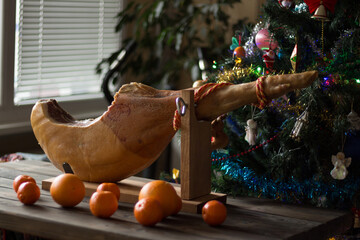 Whole Serrano ham on a Christmas tree background
