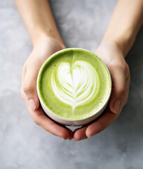 Female hands holding a cup of matcha latte - obrazy, fototapety, plakaty