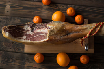 Top view of whole Serrano ham and oranges