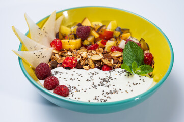 fruit, vegetarian salad with pear, raspberry, flakes on a colored plate on a white background. Light breakfast, morning