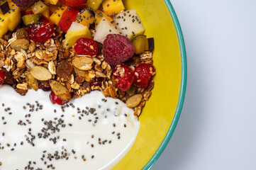 fruit, vegetarian salad with pear, raspberry, flakes on a colored plate on a white background. Light breakfast, morning