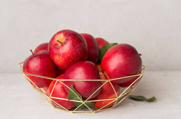 Fresh red apples in metal bowl on wooden table
