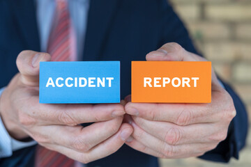 Man holding colorful blocks sees inscription: ACCIDENT REPORT. Concept of accident report. Claim injury compensation. Filling of accident report form. - obrazy, fototapety, plakaty