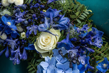 Blue and white flowers of a funeral wreath.