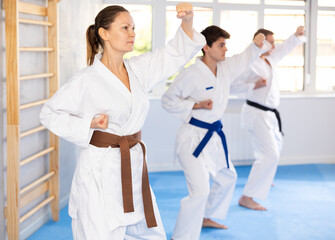In gym, certified master coach conducts karate kata lesson with students and shows sequence of...