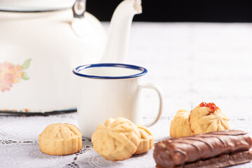 Coffee table, a beautiful coffee table with small cookies, a sweet and utensils on a lace tablecloth, dark background, selective focus.