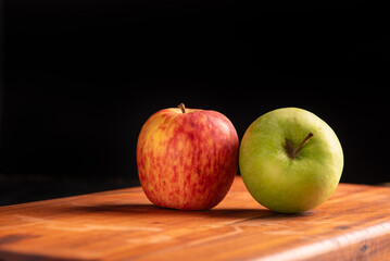 Apples, green and red apples positioned on rustic wood, dark background, selective focus.