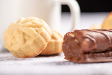 Coffee table, a beautiful coffee table with small cookies, a sweet and utensils on a lace tablecloth, dark background, selective focus.