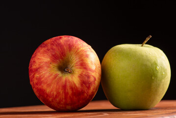 Apples, green and red apples positioned on rustic wood, dark background, selective focus.
