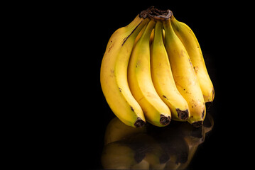 Bananas, a beautiful composition with bananas on a reflective surface with a dark background, selective focus.