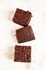 Many pieces of fresh chocolate brownie on a white table. Homemade delicious chocolate pie