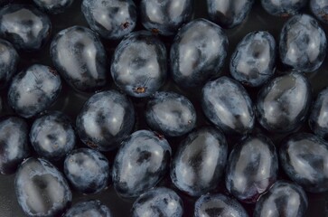 Black grapes separate berries background, closeup, top view