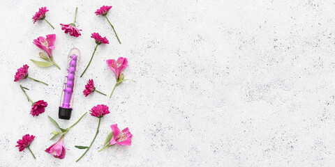 Beautiful flowers and vibrator on light background with space for text