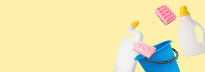 Flying cleaning supplies on yellow background with space for text