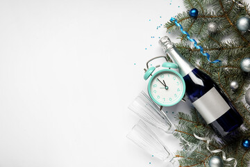 Composition with alarm clock, glasses, bottle of champagne and Christmas decorations on light background