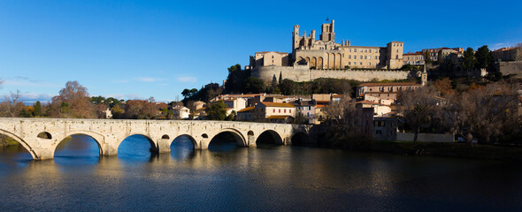 Fototapeta na wymiar Arched Old Bridge over Orb river and medieval cathedral of Saint Nazaire in Beziers