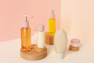 Stands with set of travel cosmetic products on color background