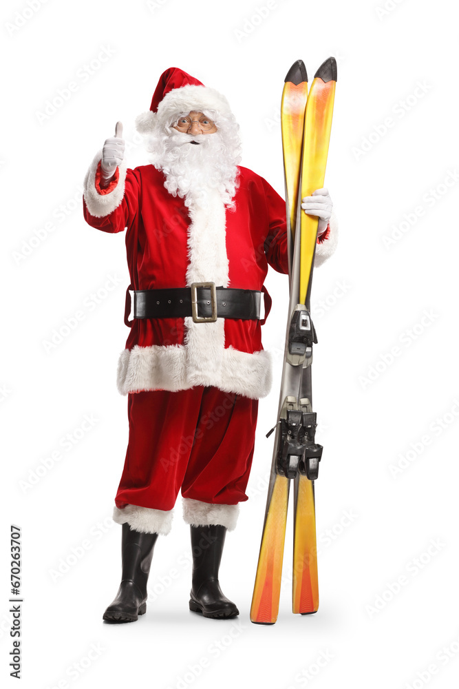 Sticker Full length portrait of Santa Claus holding a pair of skis and gesturing thumbs up