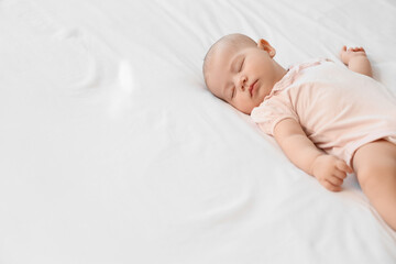 Little cute baby sleeping on bed at home