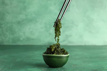 Foto op Aluminium Bowl and chopsticks with healthy seaweed on green background © Pixel-Shot