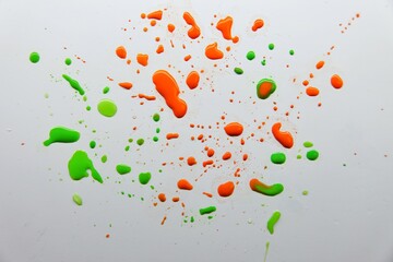White background with multi-colored liquid drops of watercolor paint. stains of paint on a glossy...
