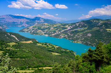 Naklejka na ściany i meble Aerial view on blue Lake of Serre-Poncon, reservoir border between Hautes-Alpes and Alpes-de-Haute Provence  departments, one of largest in Western Europe