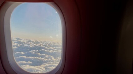 Passenger opening up aircraft porthole with bright morning clouds picturesque cloudscape view litted with sun rays and everything. 4K People traveling, wake up and transportation concept footage. - Powered by Adobe