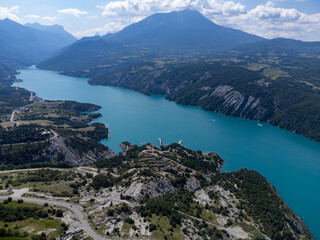 Aerial view on blue Lake of Serre-Poncon, reservoir border between Hautes-Alpes and Alpes-de-Haute Provence   departments, one of largest in Western Europe - obrazy, fototapety, plakaty