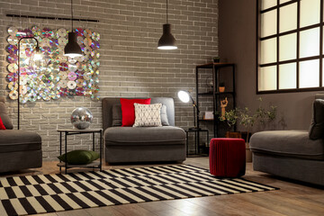 Interior of modern living room with grey armchairs and disco ball on coffee table