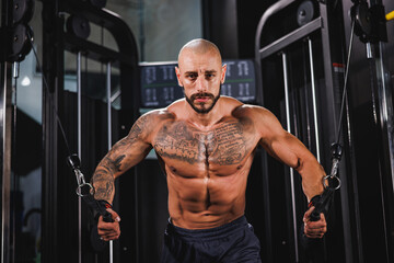 Fototapeta na wymiar Bodybuilder Preparing To Work Out Chest Muscle On A Gym Machine