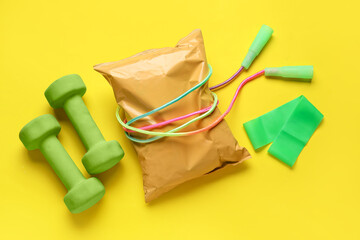 Healthy snack and sports equipment on yellow background