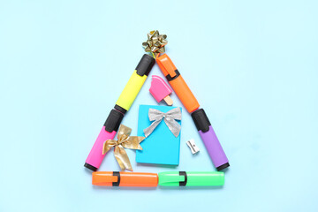 Christmas tree made of markers and bows on blue background