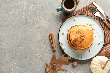 Plate of tasty pumpkin pancakes with cocoa powder and nuts on grey background - obrazy, fototapety, plakaty