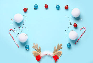 Frame made of Christmas reindeer horns with decor on blue background
