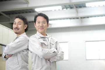 Fototapeta premium 倉庫で腕組をする笑顔の作業員2人 製造業や流通 右にコピースペースあり