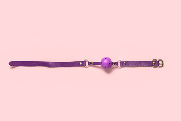 Purple mouth gag from sex shop on pink background - obrazy, fototapety, plakaty