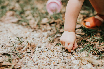 baby girl hand playing outside in rocks