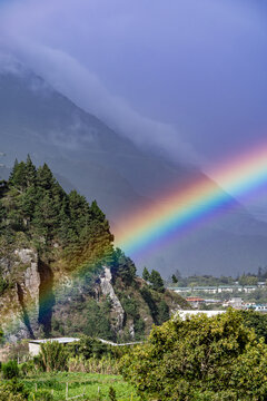 Beautiful view of the rainbow over the  volcanoes in the city of Banos, Ecuador. Amazing sunset.