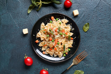 Plate with tasty pasta primavera on black background
