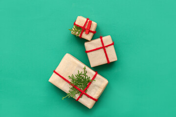 Christmas gift boxes with coniferous branches on green background