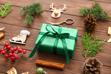 Gift box with Christmas tree branches, cinnamon and beautiful decorations on wooden background