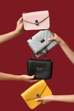 Female hands with stylish purses on red background. Black Friday sale